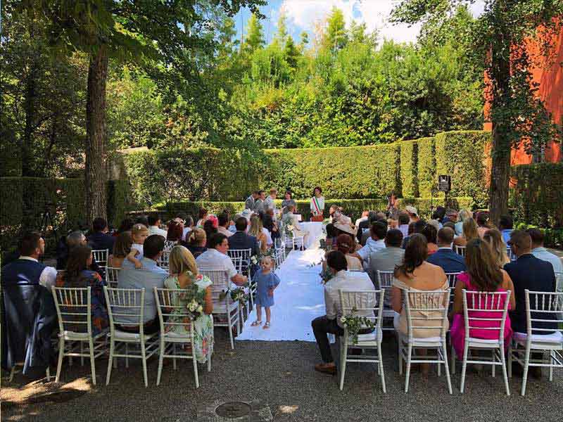 The ceremony area was surrounded by tall trees, providing some relief from the heat.